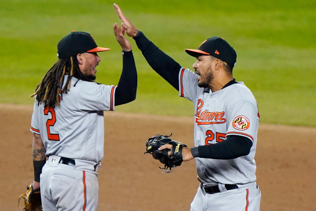 Anthony Santander and teammate celebrate Orioles baseball win with high-five on field wallpaper background