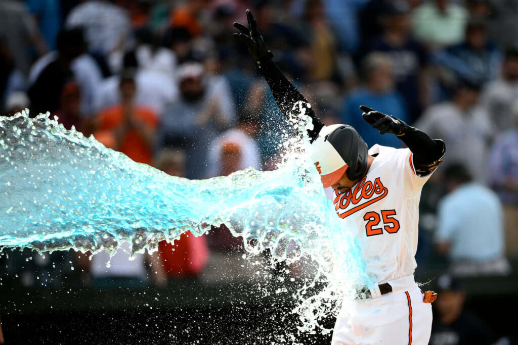 Anthony Santander celebrating on baseball field with dynamic water splash vibrant game energy wallpaper