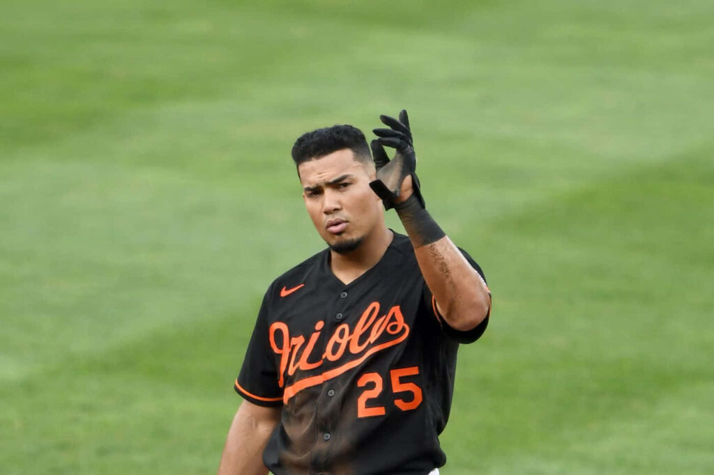 Athlete Anthony Santander in Orioles uniform swinging bat mid-action dynamic baseball wallpaper