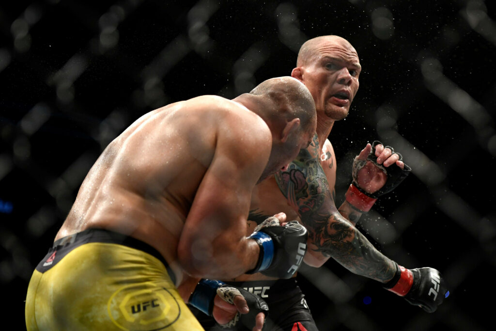 Anthony Smith lands a powerful punch in UFC fight showing strength determination inside octagon Wallpaper