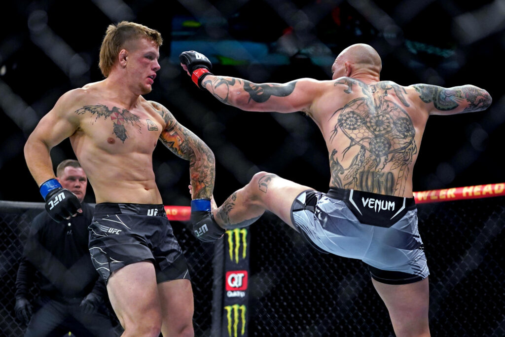 Anthony Smith blocking a powerful kick inside the UFC octagon dynamic MMA fight action wallpaper