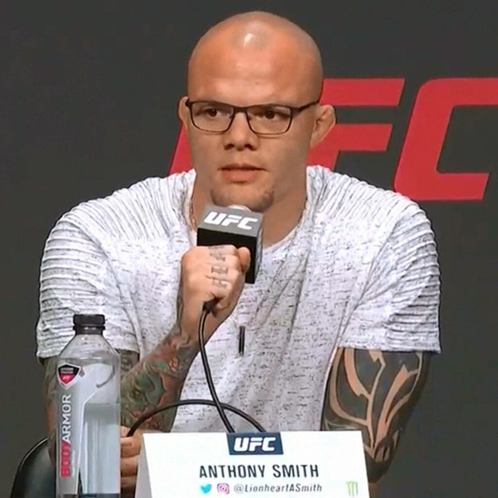 UFC fighter Anthony Smith tattooed and focused speaking into microphone at press conference wallpaper
