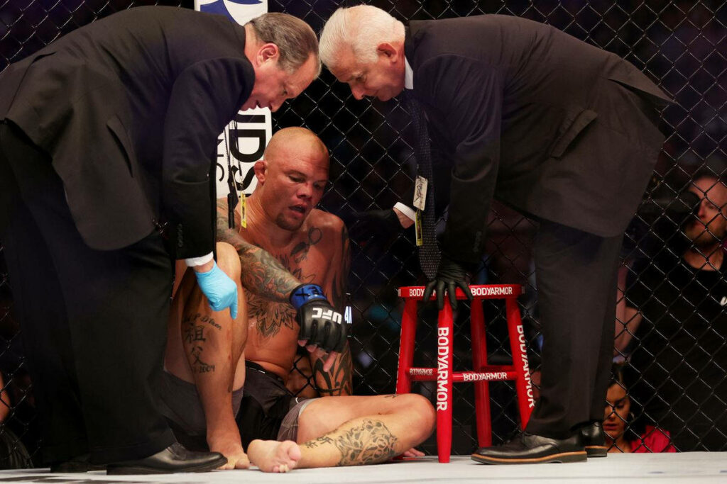 Anthony Smith in UFC octagon corner getting team support during intense fight moment wallpaper