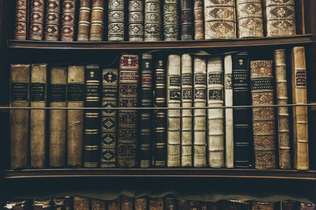 Close-up of antique books on wooden shelves vintage wallpaper for classic literature lovers