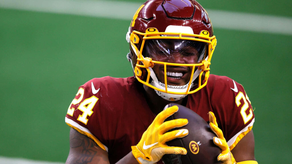 Antonio Gibson focused catching football during intense game dynamic sports wallpaper background