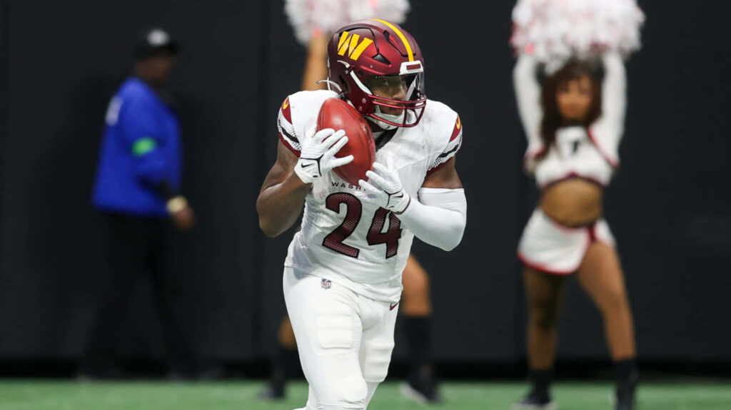 Antonio Gibson in action for Washington Commanders focused advancing play football game wallpaper