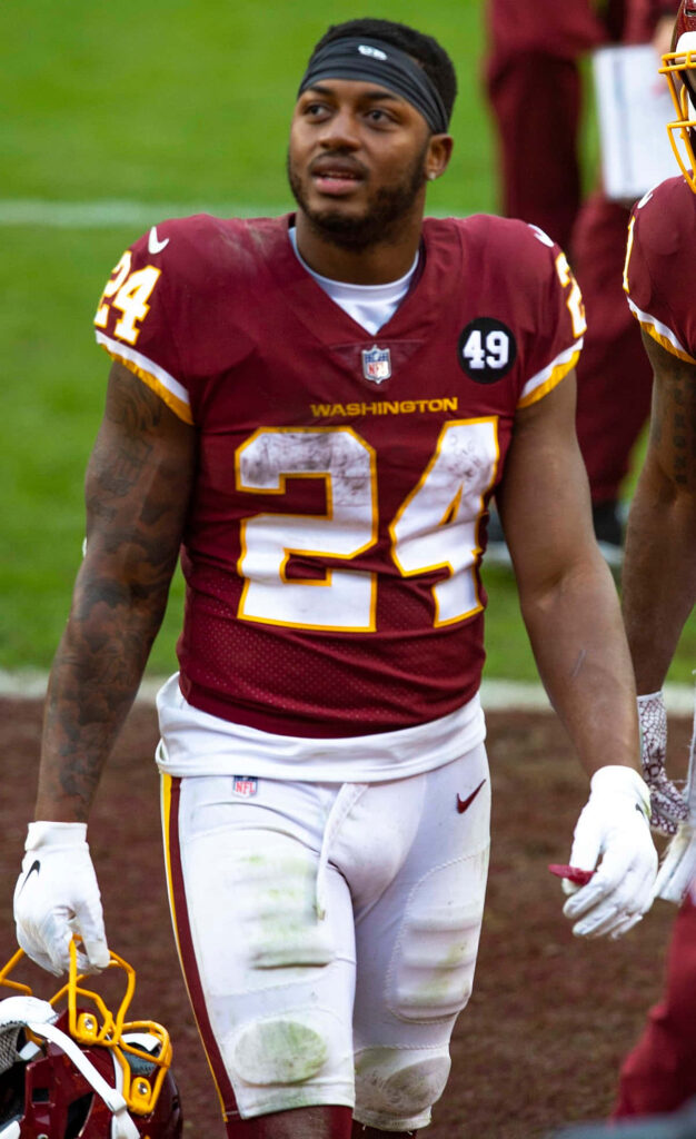 Antonio Gibson Washington Football Team in burgundy gold uniform on field determined after game Wallpaper