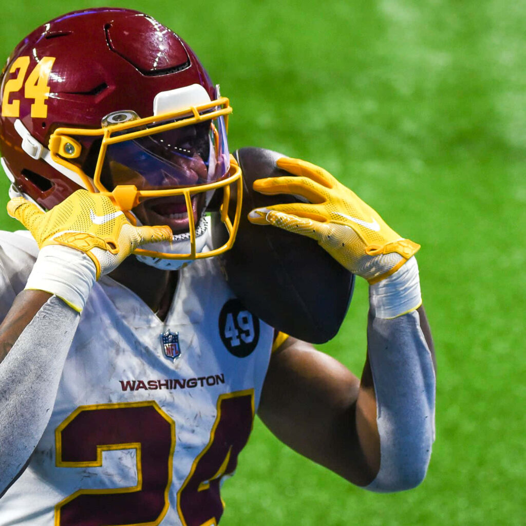 Antonio Gibson celebrates touchdown in Washington football uniform holding ball energetic moment Wallpaper