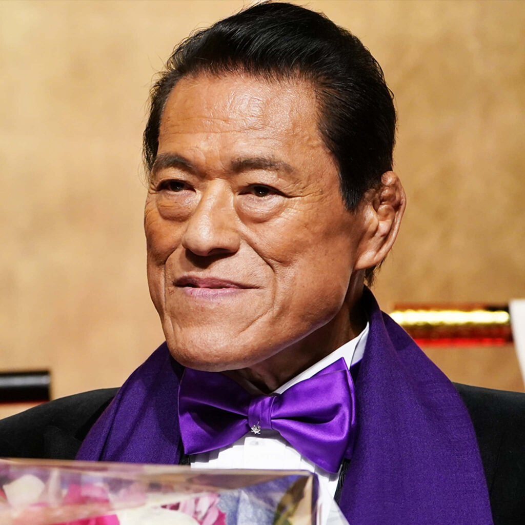Antonio Inoki in a stylish purple suit and bow tie distinguished wallpaper background
