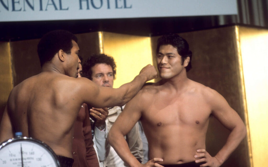 Antonio Inoki and Muhammad Ali shirtless face off capturing historic boxing wrestling match tension Wallpaper