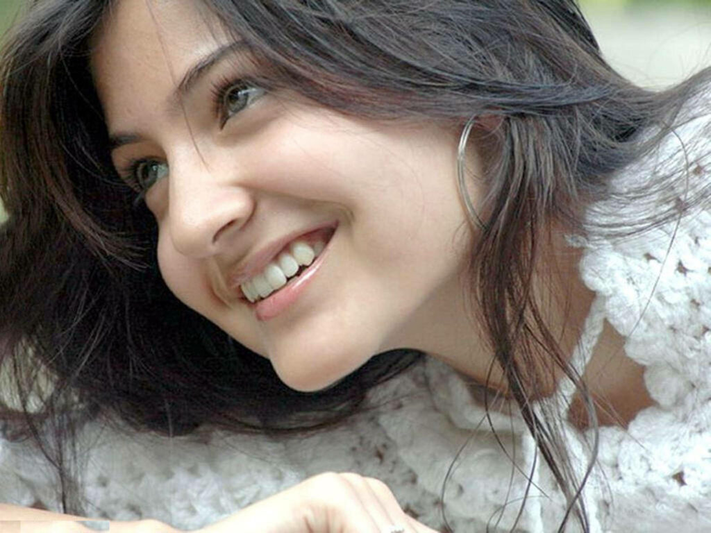 Anushka Sharma side pose smiling natural light highlighting features charming wallpaper background