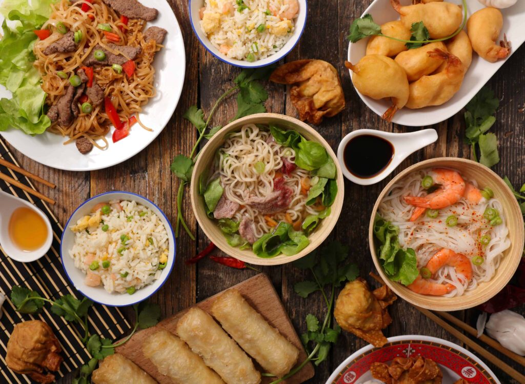 Delicious Asian Cuisine Spread: Noodles, Dumplings & Herbs Wallpaper