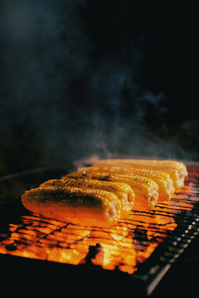 Golden Corn Cobs Grilled Over Coals - Appetizing Wallpaper Background