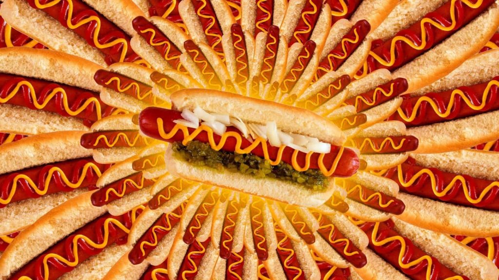 Appetizing hot dog wallpaper with radial sunburst and detailed mustard relish onion topping pattern