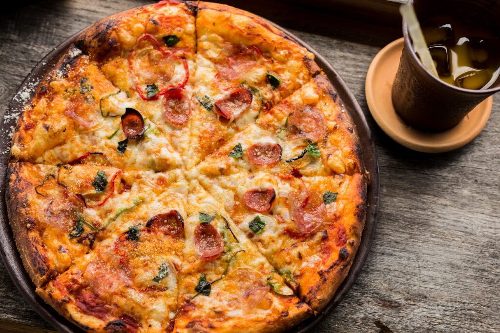 Appetizing Pizza with Fresh Toppings on Wooden Surface Wallpaper