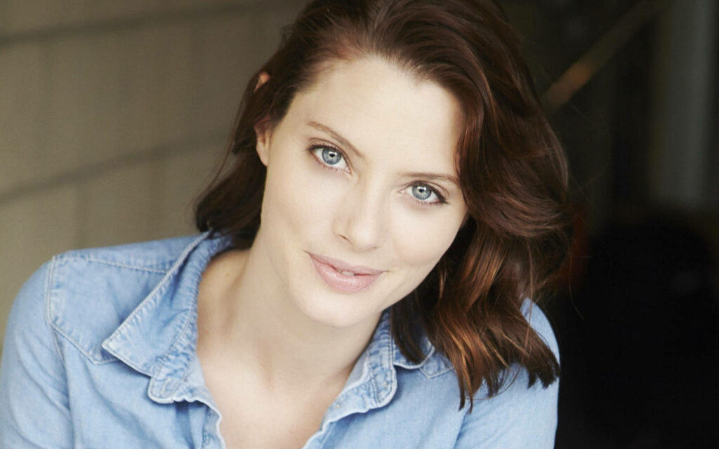 April Bowlby radiant in light denim top with soft background highlighting her beauty and eyes Wallpaper