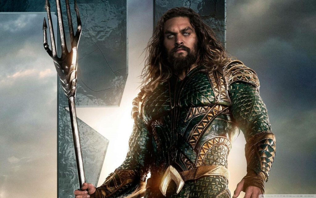 Aquaman in green and gold armor holding trident against epic ocean background wallpaper