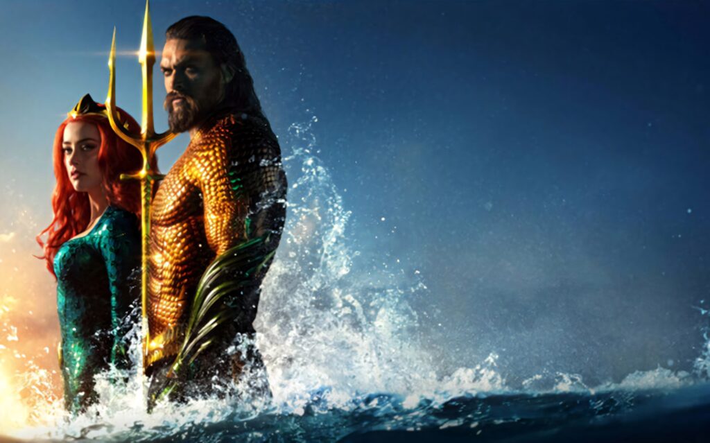 Aquaman and Mera in iconic costumes rising from ocean with splashing water and dramatic sky wallpaper