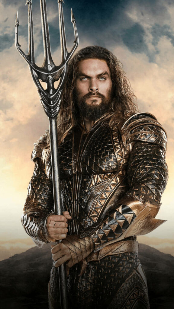 Aquaman in iconic armor holding trident against dramatic sky wallpaper background hero pose