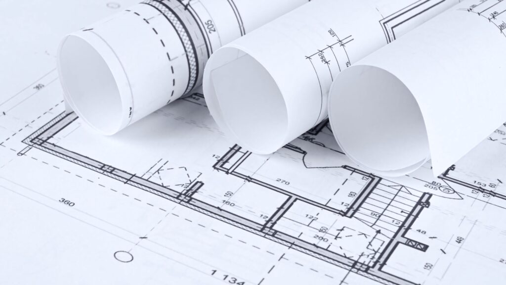 Detailed civil engineering blueprints with rolled plans on white background showing structural layouts Wallpaper