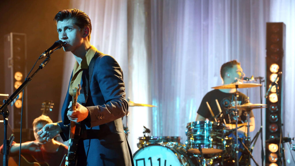 Arctic Monkeys live performance with Alex Turner singing and playing guitar on stage wallpaper
