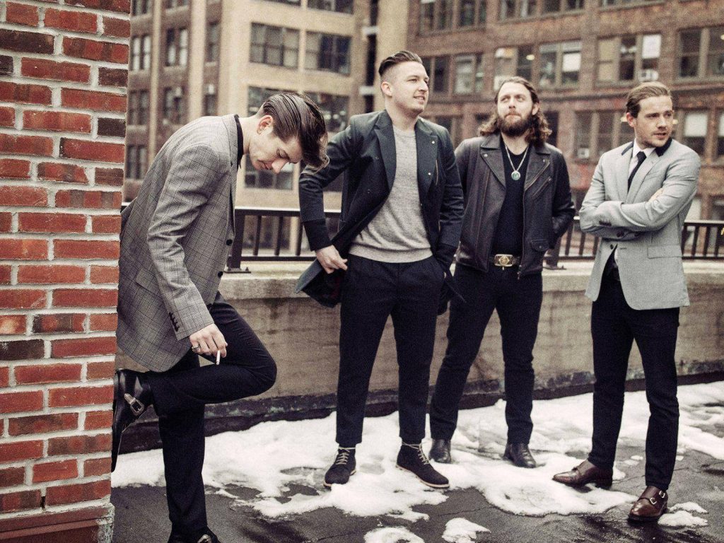Arctic Monkeys on snowy urban rooftop wearing sharp jackets cinematic stylish wallpaper background