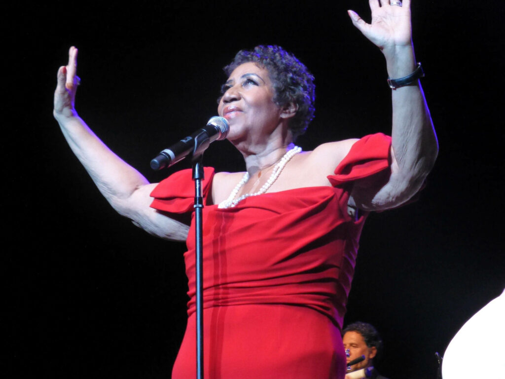 Aretha Franklin singing passionately in red dress iconic singer-songwriter pianist wallpaper background