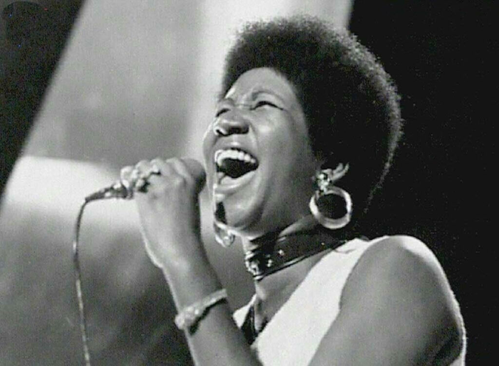 Aretha Franklin passionately singing on stage iconic American singer songwriter performance wallpaper