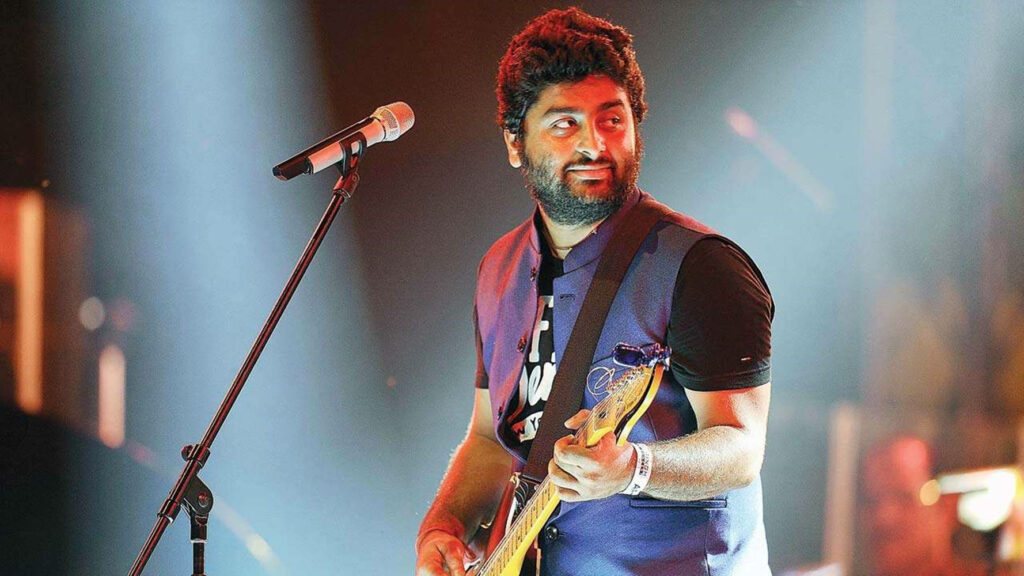 Arijit Singh passionately playing guitar live on stage energetic music wallpaper background