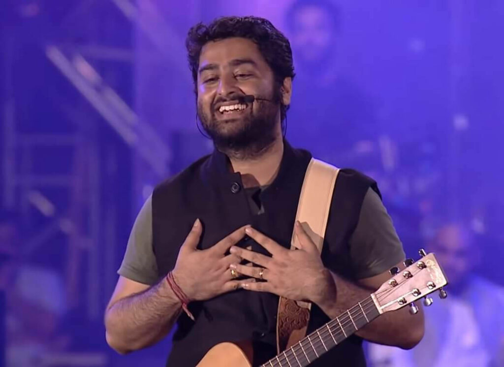 Arijit Singh singing live on stage with guitar vibrant emotional concert atmosphere wallpaper