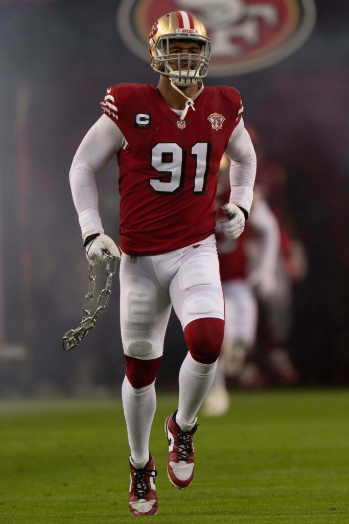 San Francisco 49ers Arik Armstead runs onto field holding chain in red gold uniform vs Arizona Cardinals Wallpaper