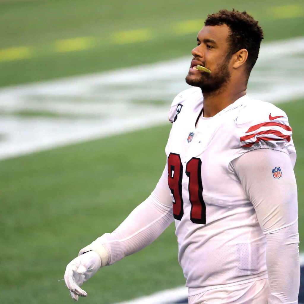 Arik Armstead in white football uniform focused during dynamic dutch angle field action shot Wallpaper