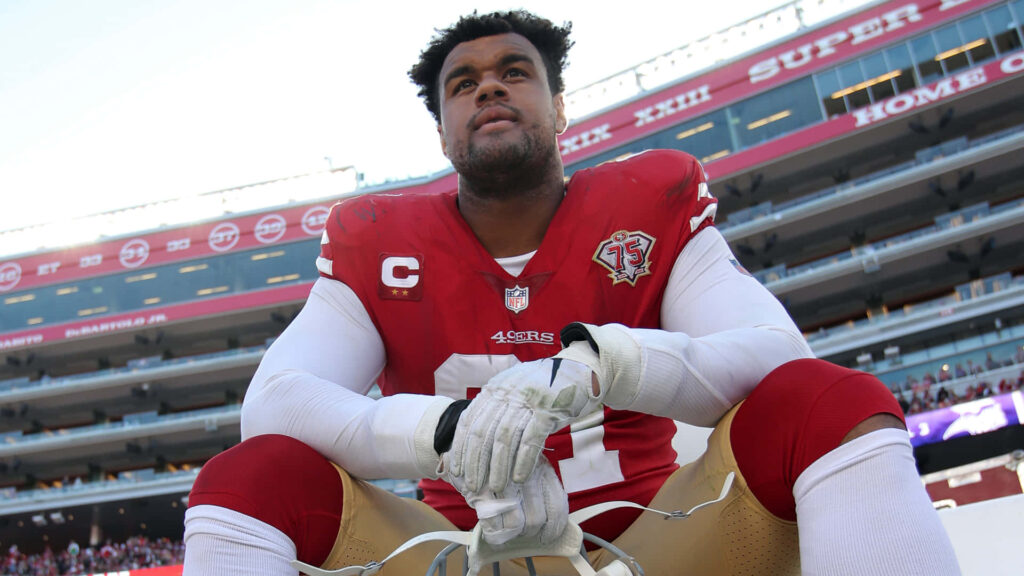 Arik Armstead resting on field in football uniform showing focus and determination wallpaper