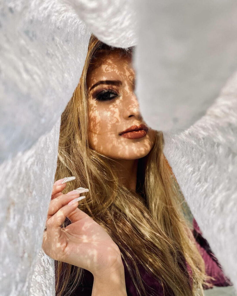 Arishfa Khan partially covered by white blanket with sunlight patterns on face and hand cozy wallpaper