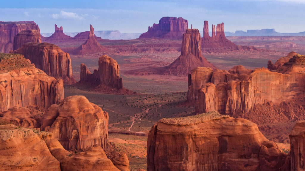 Arizona desert rock formations with dramatic mesas and buttes under clear blue sky wallpaper