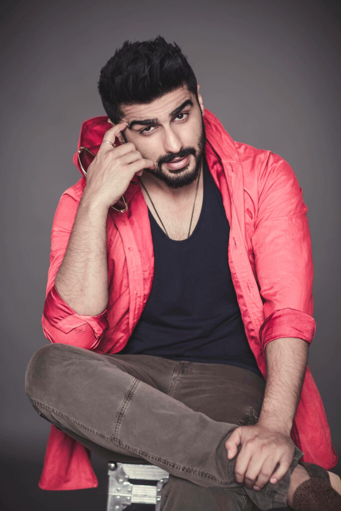 Indian actor Arjun Kapoor confident in red jacket black shirt grey background wallpaper background