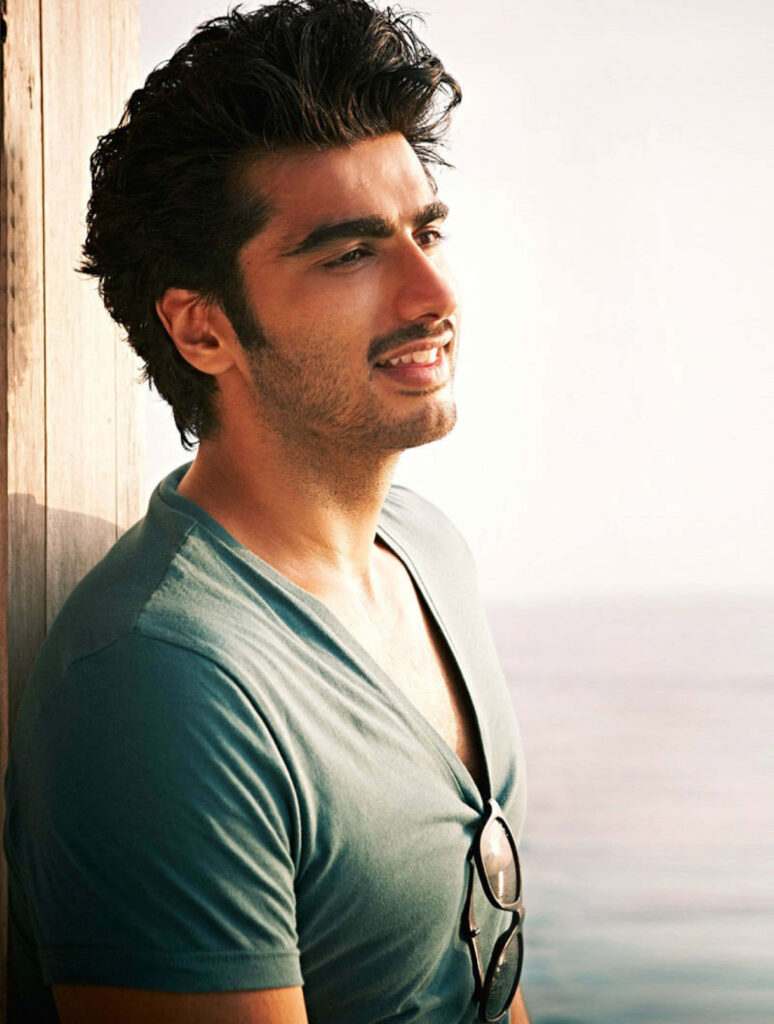 Arjun Kapoor standing by water with sunlight highlighting his features stylish wallpaper background