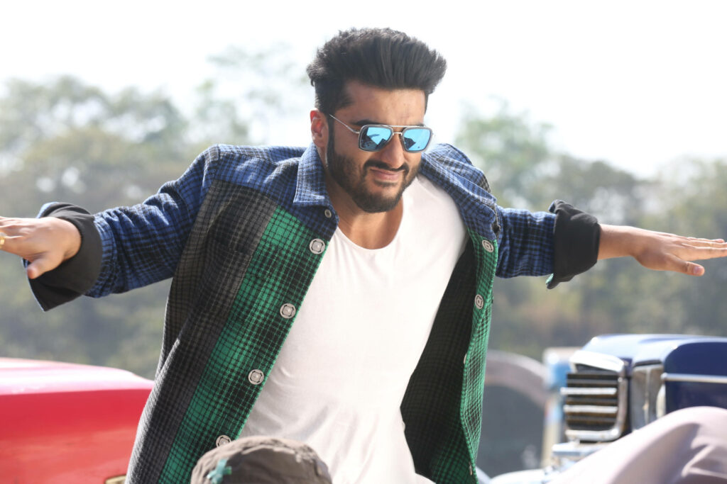 Arjun Kapoor in sunglasses and checked jacket striking humorous pose lively wallpaper background