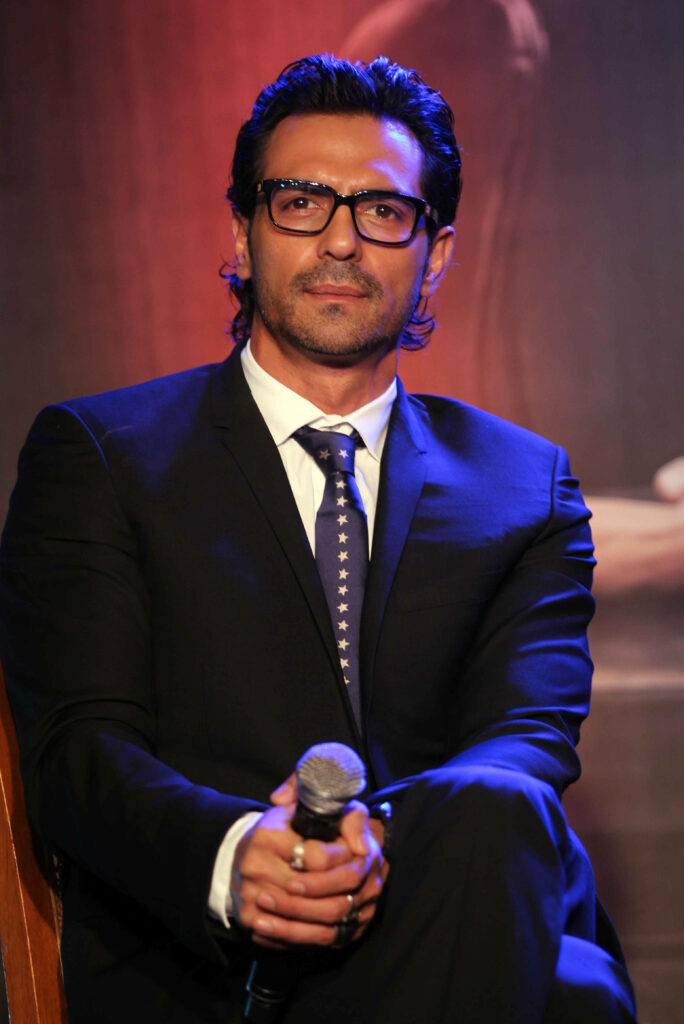 Arjun Rampal seated in black suit and glasses exuding confidence and sophistication wallpaper