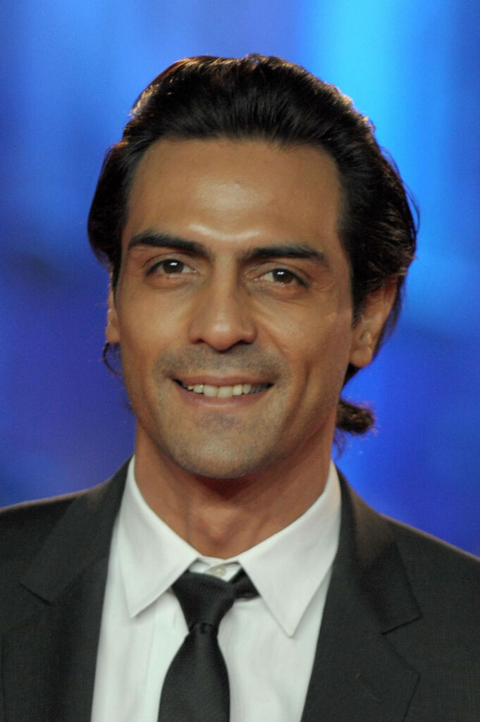 Arjun Rampal smiling in formal suit with soft blue blurred background wallpaper image