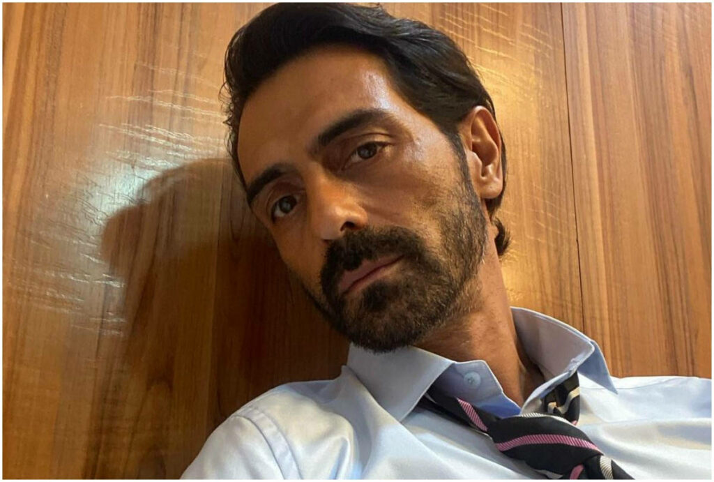 Arjun Rampal in stylish formal attire posing against wooden wall background elegant wallpaper