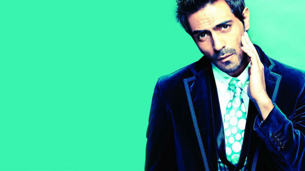 Arjun Rampal in stylish suit posing thoughtfully against vibrant green modern wallpaper background