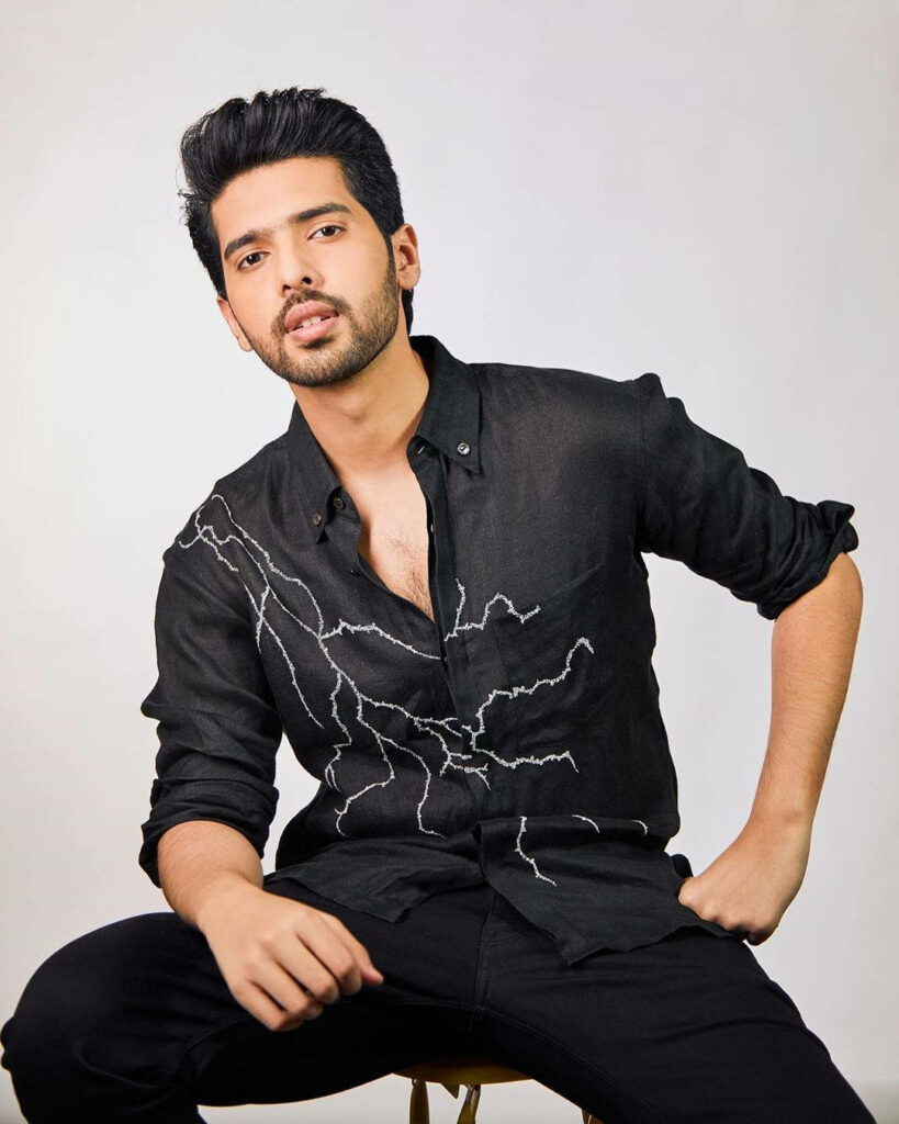 Armaan Malik in black shirt with white lightning pattern bold modern wallpaper background