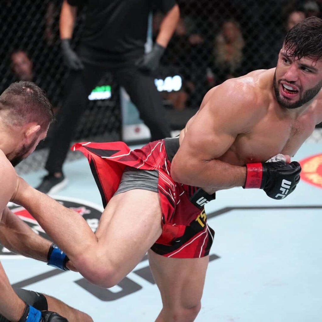 Arman Tsarukyan delivering a powerful kick inside the octagon showcasing athleticism and focus Wallpaper