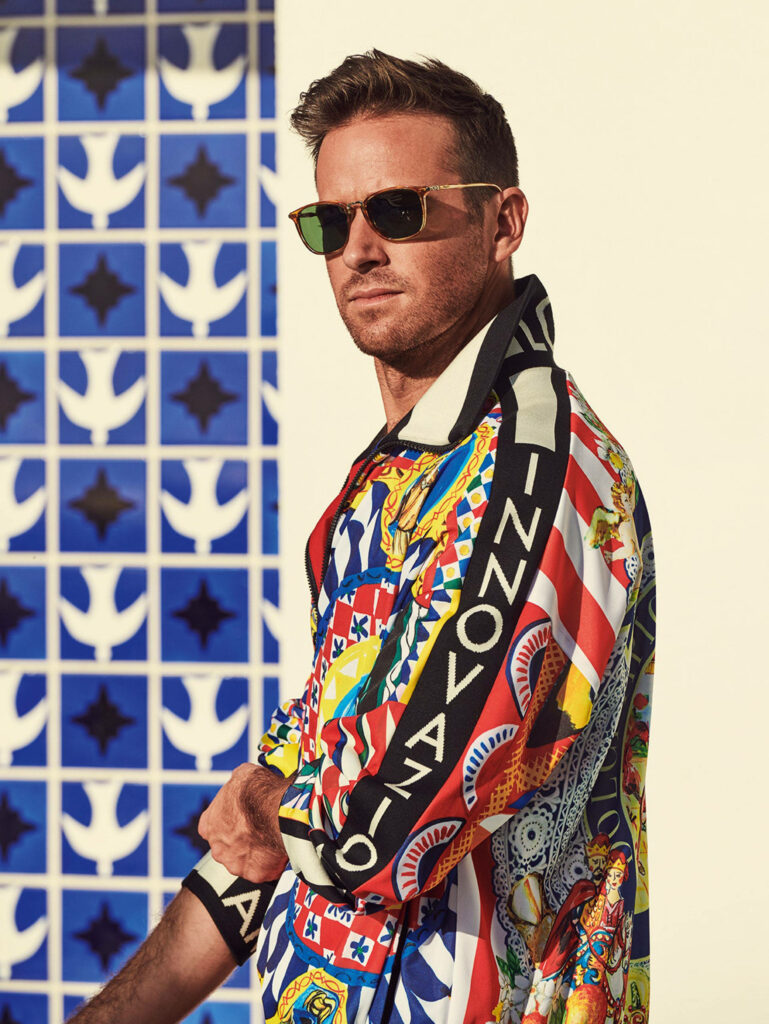 Armie Hammer in vibrant patterned jacket posing confidently against stylish tiled background Wallpaper