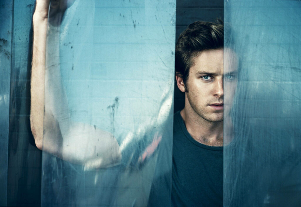 Armie Hammer intense gaze behind translucent glass striking photoshoot wallpaper background