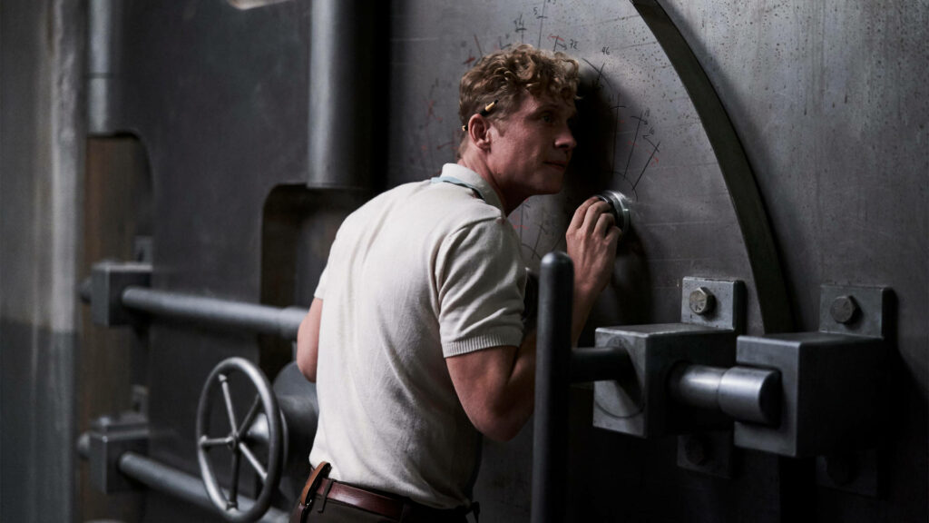 Tense scene from Army of the Dead character listens closely unlocking massive vault door wallpaper