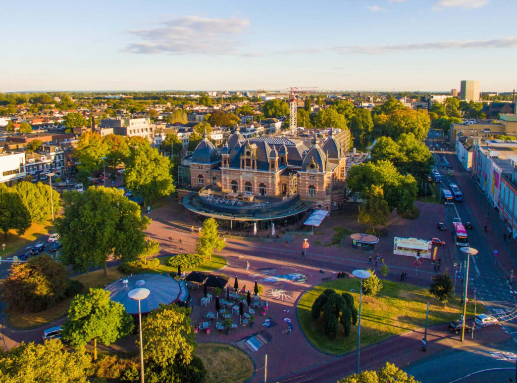 Aerial view of Arnhem city with historic buildings and green trees under a clear blue sky wallpaper
