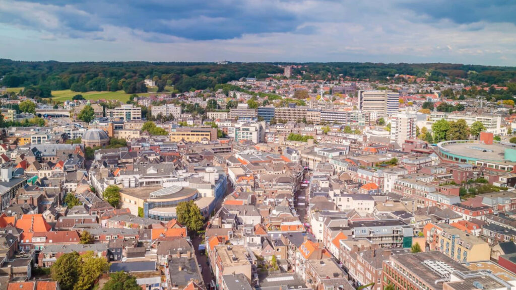 Aerial view of Arnhem cityscape blending historic and modern buildings with lush greenery sky Wallpaper