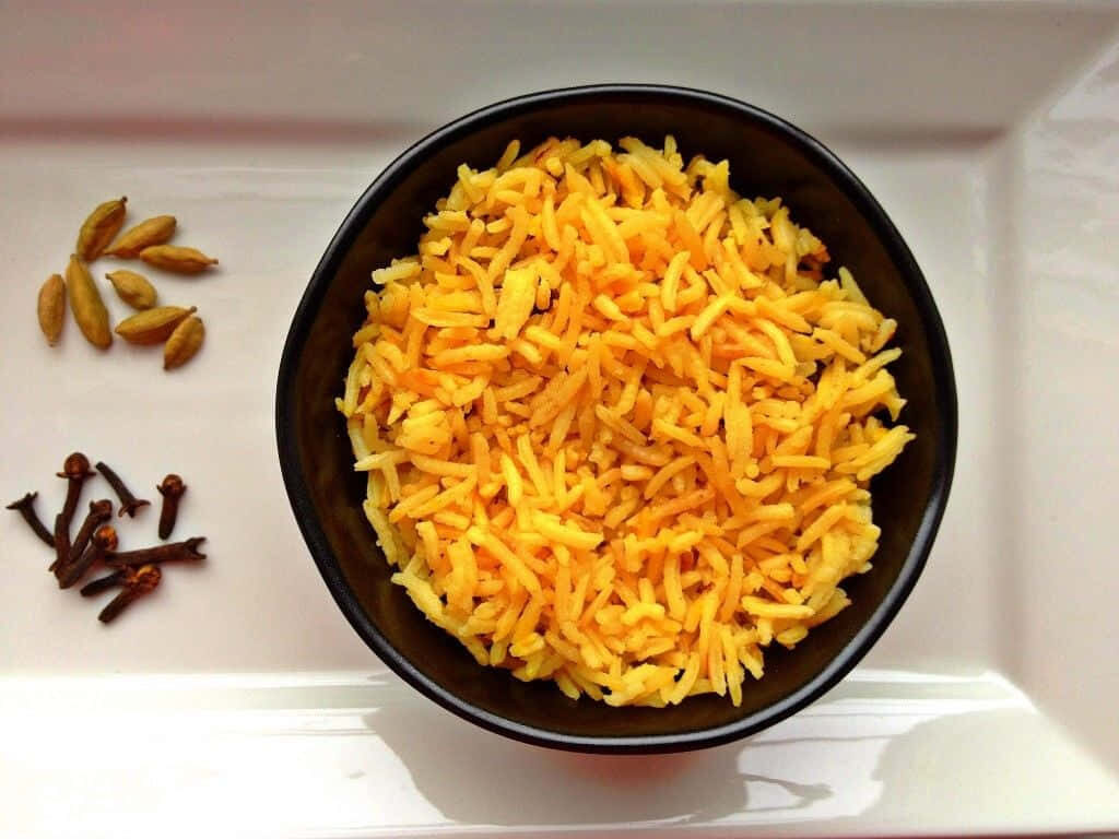 Aromatic Yellow Rice Bowl with Spices - Indian Cuisine Wallpaper